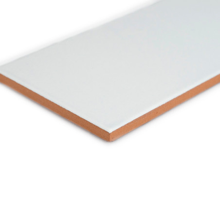 Azulejo de cerámica blanca rectangular con una superficie lisa y una base de color marrón rojizo, vista en ángulo sobre un fondo Azulejo de cerámica blanca rectangular con una superficie lisa y una base de color marrón rojizo, vista en ángulo sobre un fondo