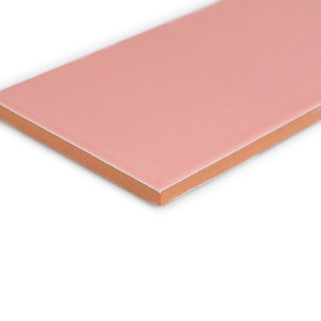 Un carreau rectangulaire, lisse et rose repose sur un fond blanc, mettant en valeur ses bords nets et son dessous de couleur ter Un carreau rectangulaire, lisse et rose repose sur un fond blanc, mettant en valeur ses bords nets et son dessous de couleur ter