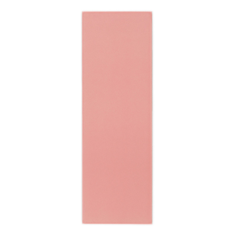 Een rechthoekige, effen roze tegel rust rechtop tegen een effen witte achtergrond en laat het gladde, matte oppervlak zien.