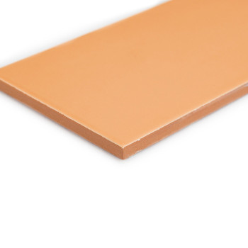 Um ladrilho retangular bege fica plano, exibindo uma superfície lisa e sem textura e bordas afiadas, filmado em um fundo branco 