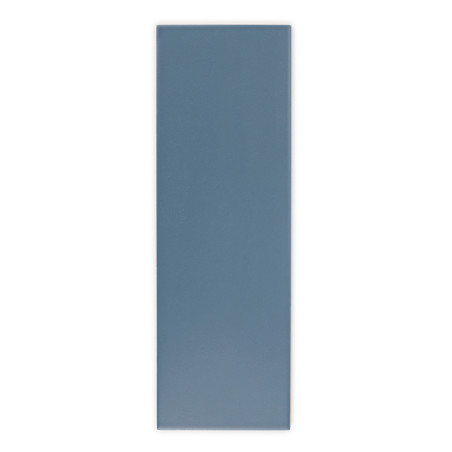 Un azulejo rectangular de color azul mate se alza verticalmente sobre un fondo blanco liso, mostrando una superficie lisa y unif