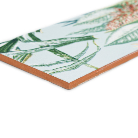 Um azulejo cerâmico exibe um padrão detalhado de folhas tropicais verdes e laranja, contra um fundo branco. Um azulejo cerâmico exibe um padrão detalhado de folhas tropicais verdes e laranja, contra um fundo branco.