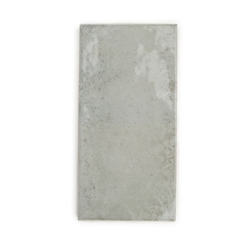 Una losa de concreto rectangular de color gris claro muestra motas sutiles y texturas irregulares, lo que sugiere una apariencia