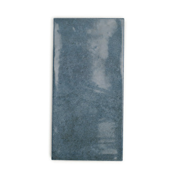 Carreau de céramique rectangulaire, présentant une surface bleu-gris brillante et trouble. apparaît sur un fond blanc uni.