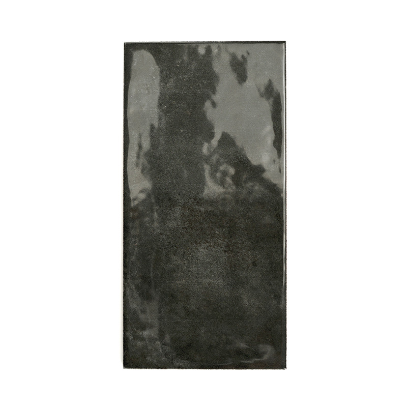 Carreau rectangulaire noir brillant, réfléchissant la lumière, centré sur un fond blanc uni.