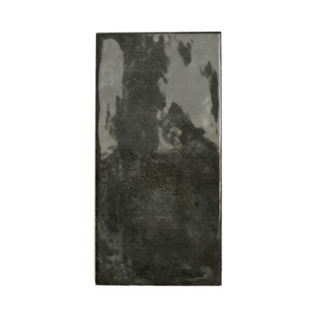 Rechteckige glänzende schwarze Fliese, die Licht reflektiert, mittig auf einem schlichten weißen Hintergrund.