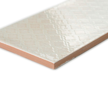 Un carreau de céramique rectangulaire repose en diagonale et présente une surface brillante à motif de losanges. Ses bords révèl
