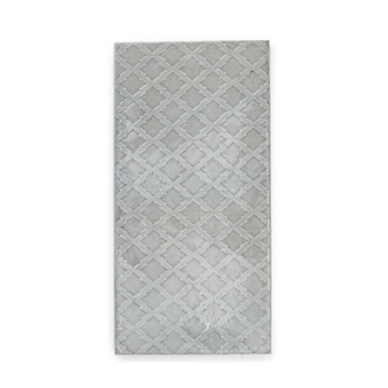 Le carreau rectangulaire présente un motif de treillis géométrique dans des tons gris clair, sur un fond doux et texturé, adapté