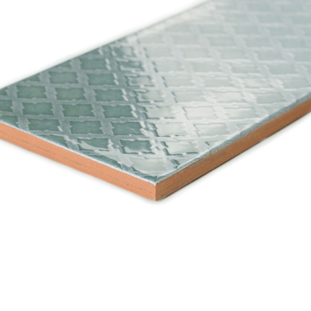 Un azulejo de cerámica muestra un patrón geométrico brillante con formas entrelazadas en tonos azul claro, sobre un fondo blanco Un azulejo de cerámica muestra un patrón geométrico brillante con formas entrelazadas en tonos azul claro, sobre un fondo blanco
