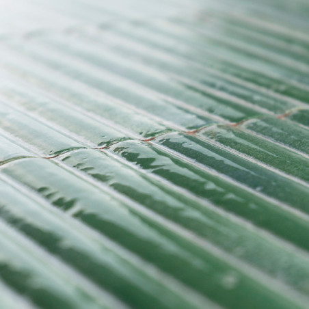 Ladrilhos cerâmicos verdes dispostos em fileira, refletindo a luz, criando uma aparência brilhante. A superfície é ligeiramente Ladrilhos cerâmicos verdes dispostos em fileira, refletindo a luz, criando uma aparência brilhante. A superfície é ligeiramente
