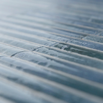 De focus ligt op getextureerde, rechthoekige glastegels, uitgelijnd in parallelle rijen. Licht reflecteert zachtjes op het gladd
