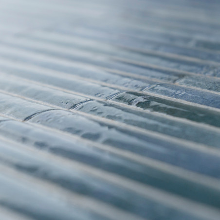 L'accent est mis sur les carreaux de verre texturés et rectangulaires, alignés en rangées parallèles. La lumière se reflète douc