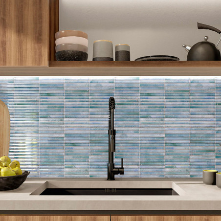 Blaue Mosaikfliesen säumen die Küchenrückwand und ergänzen einen schwarzen Wasserhahn über einem Waschbecken. Holzschränke und T