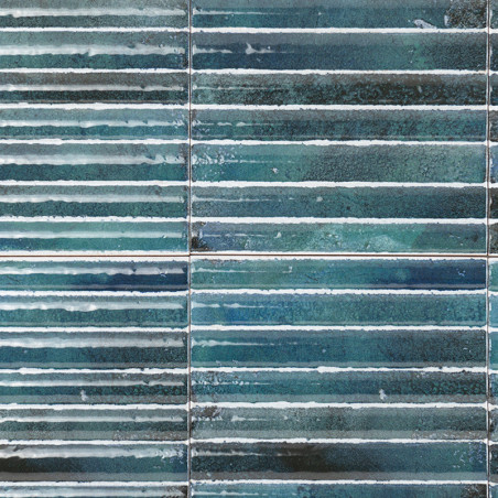 Rechthoekige tegels vertonen horizontale blauwgroene strepen, waardoor een gestructureerd effect ontstaat. Ze zijn gelijkmatig g