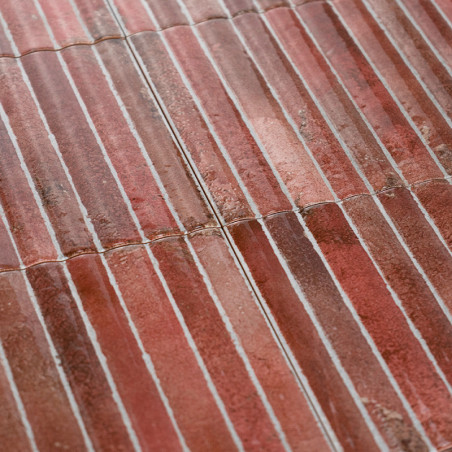 Les carreaux de céramique rectangulaires forment des rangées, affichant un dégradé de teintes rougeâtres, avec des lignes de cou Les carreaux de céramique rectangulaires forment des rangées, affichant un dégradé de teintes rougeâtres, avec des lignes de cou