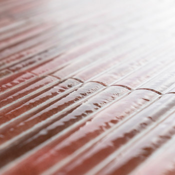 La surface du carrelage présente des motifs linéaires striés créant un effet texturé, réfléchissant subtilement la lumière dans 