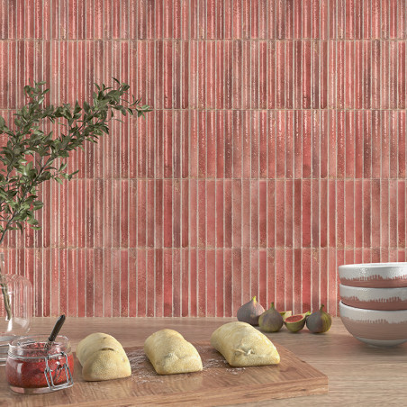 Les carreaux rouges à rayures verticales créent une toile de fond dans une cuisine. Au premier plan, la pâte repose sur une plan Les carreaux rouges à rayures verticales créent une toile de fond dans une cuisine. Au premier plan, la pâte repose sur une plan