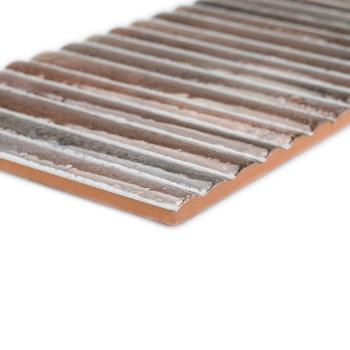 Un carreau de céramique rectangulaire marron présente des crêtes surélevées et une surface texturée inégale. Il est incliné sur 
