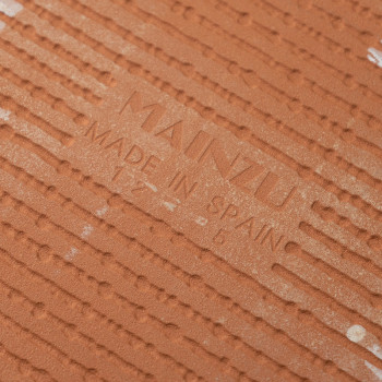 Le carreau en terre cuite affiche le texte « MAINZU MADE IN SPAIN » en relief au centre, entouré de crêtes parallèles pour la te