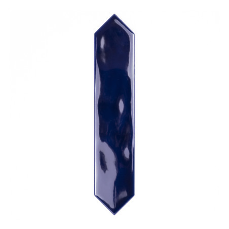 Un carreau bleu foncé brillant aux extrémités pointues se trouve verticalement sur un fond blanc uni, réfléchissant la lumière s