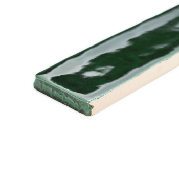 Eine rechteckige, glänzend grüne Fliese liegt flach und reflektiert das Licht in einem glatten Oberflächenmuster vor einem weiße