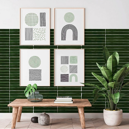 Framed abstract art hangs on a wall with horizontal green tiles. A wooden bench below holds a potted plant and books, with a lar Framed abstract art hangs on a wall with horizontal green tiles. A wooden bench below holds a potted plant and books, with a lar