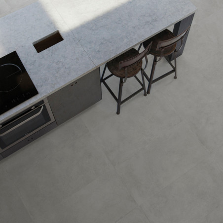 Una isla de cocina minimalista cuenta con una encimera gris con una estufa integrada y una zona para sentarse con dos taburetes 