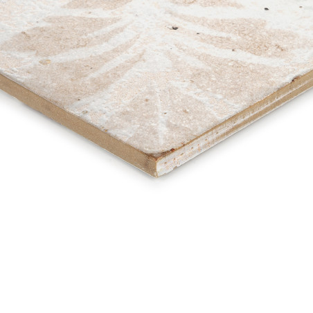 Eine Keramikfliese zeigt ein verblasstes, symmetrisches Muster mit Beige- und Cremetönen vor einem schlichten weißen Hintergrund