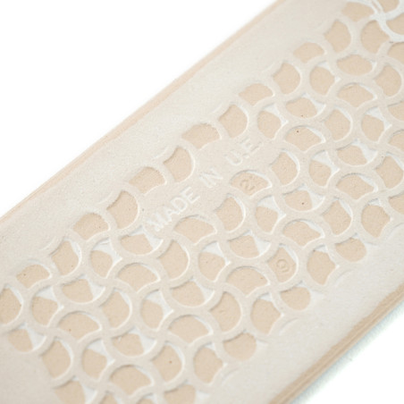 Beige getextureerde tegels vertonen een ingewikkeld geometrisch patroon met verhoogde halve cirkels. De tekst `MADE IN UAE` is c