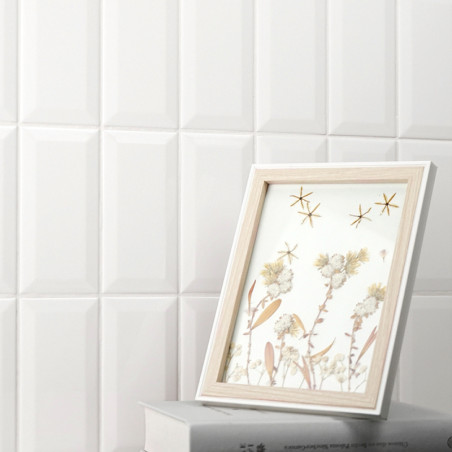 Uma imagem com moldura de madeira exibe arte floral ao lado de motivos de estrelas, apoiada em dois livros empilhados contra uma