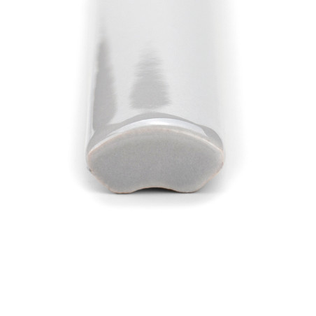 Un carreau de céramique blanc lisse et brillant avec une surface incurvée se trouve sur un fond blanc uni.