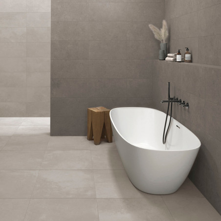 Uma moderna banheira branca assenta sobre grandes azulejos bege, adjacente a uma parede com decoração minimalista, incluindo um 