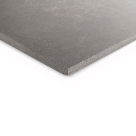 Un carreau de céramique gris est incliné sur un fond blanc, mettant en valeur sa surface lisse et ses bords légèrement biseautés