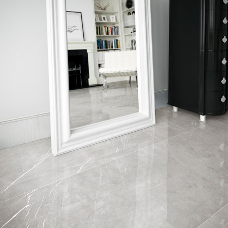 Un gran piso de azulejos blancas reflectantes realza la amplitud de una habitación, con un espejo con marco blanco y una cómoda 