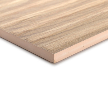 Un carreau stratifié rectangulaire à texture de bois repose à un angle, mettant en valeur ses fines couches et son motif de grai