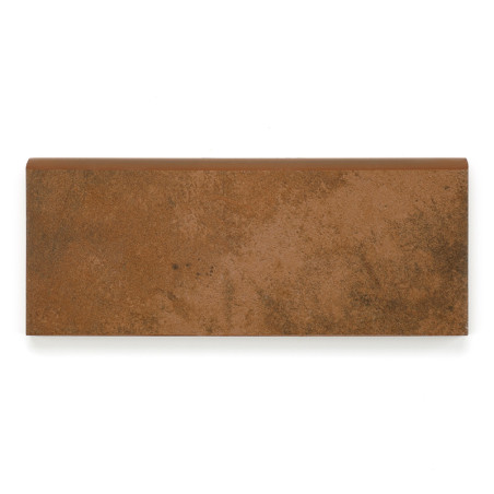 Rodapé rectangular em cerâmica castanha com superfície texturizada assente sobre fundo liso branco, sugerindo a sua utilização na construção ou decoração.