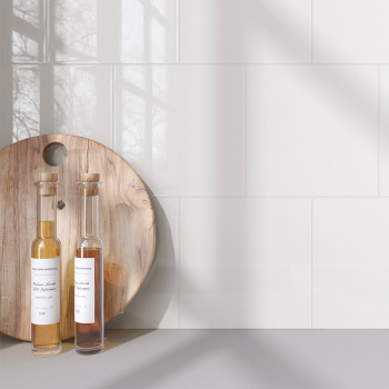 Op een houten ronde plank staan ​​twee flessen met kurken stoppen. de tekst leest `Traditionele Azijn Vineux & Okkernoot. Netto 