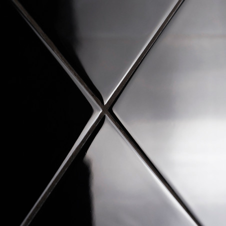 Cuatro azulejos de cerámica negra brillante se encuentran en un punto central, formando una `X` con reflejos de luz que acentúan