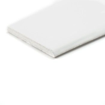 Une plinthe blanche longue et étroite repose sur un fond blanc, soulignant sa simplicité et son design épuré.
