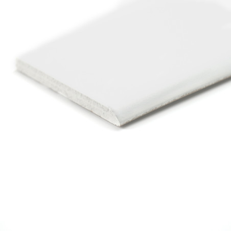 Um rodapé branco retangular fica plano e exibe uma superfície superior lisa e uma borda levemente texturizada em um fundo branco liso. Um rodapé branco retangular fica plano e exibe uma superfície superior lisa e uma borda levemente texturizada em um fundo branco liso.