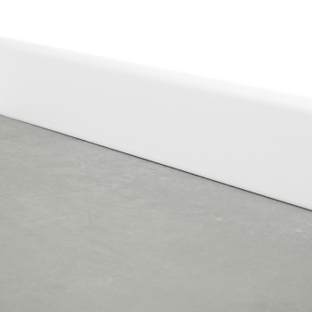 Eine schlichte graue Fußleiste liegt flach, begrenzt durch eine weiße Fußleiste, an der Schnittstelle zwischen Boden und Wand in einem minimalistischen Raum.