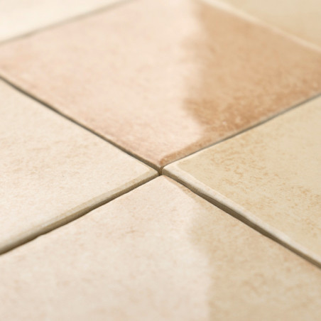 Square ceramic tiles align seamlessly, with one tile featuring a gradient brown and cream pattern, placed closely in a grid on a