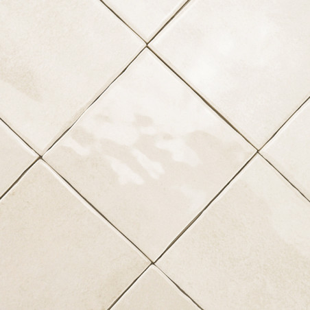 Des carreaux de céramique beiges disposés en diagonale forment un motif en losange. surface lisse avec une texture subtile, créa