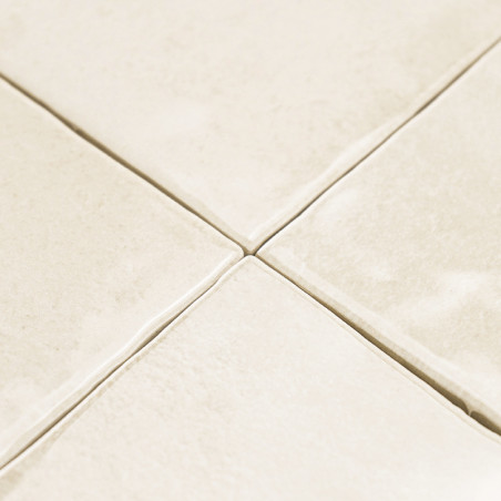 azulejos cerámicos de color crema dispuestas en forma de cuadrícula, con una textura ligera y líneas de lechada visibles, creand