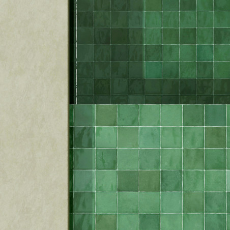 Grüne Keramikfliesen bilden ein geometrisches Muster und bilden eine glatte, reflektierende Oberfläche an einer vertikalen Wand,