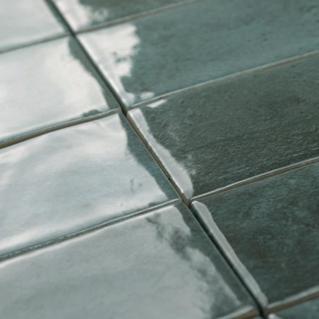 Les carreaux de céramique scintillent, réfléchissant la lumière, créant un motif de grille brillant dans un décor intérieur. Les