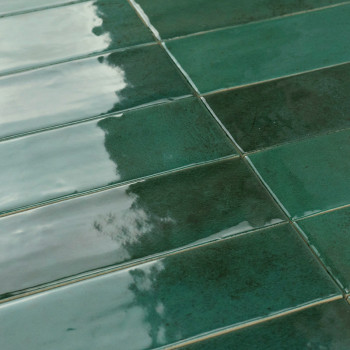 Los azulejos rectangulares verdes reflejan la luz, creando un brillo brillante. Ubicado en un patrón de cuadrícula, la textura s