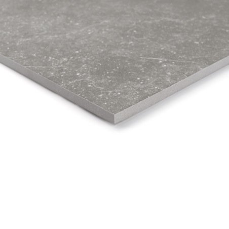 Un carreau de céramique carré gris présente de subtiles taches blanches, posées à plat sur une surface blanche unie, mettant en 