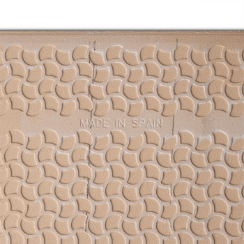 A textured tile displays a repeating pattern of curved shapes. Centered text reads `MADE IN SPAIN,` surrounded by a beige surfac