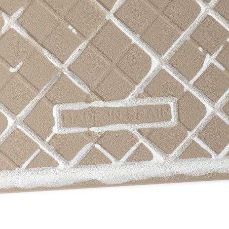 Eine hellbraune Fliese weist ein erhabenes Rautengittermuster auf, das mit weißem Fugenmörtel gefüllt ist. Der Text „MADE IN SPA